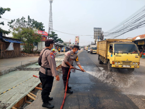 Polsek Pasar Kemis Siram Jalan Kurangi Debu Abu Vulkanik